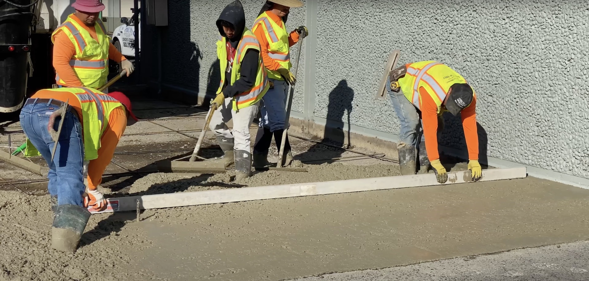 Expert concrete installation by Waterbury Concrete Construction team Professional concrete workers smoothing freshly poured concrete surface in Waterbury CT