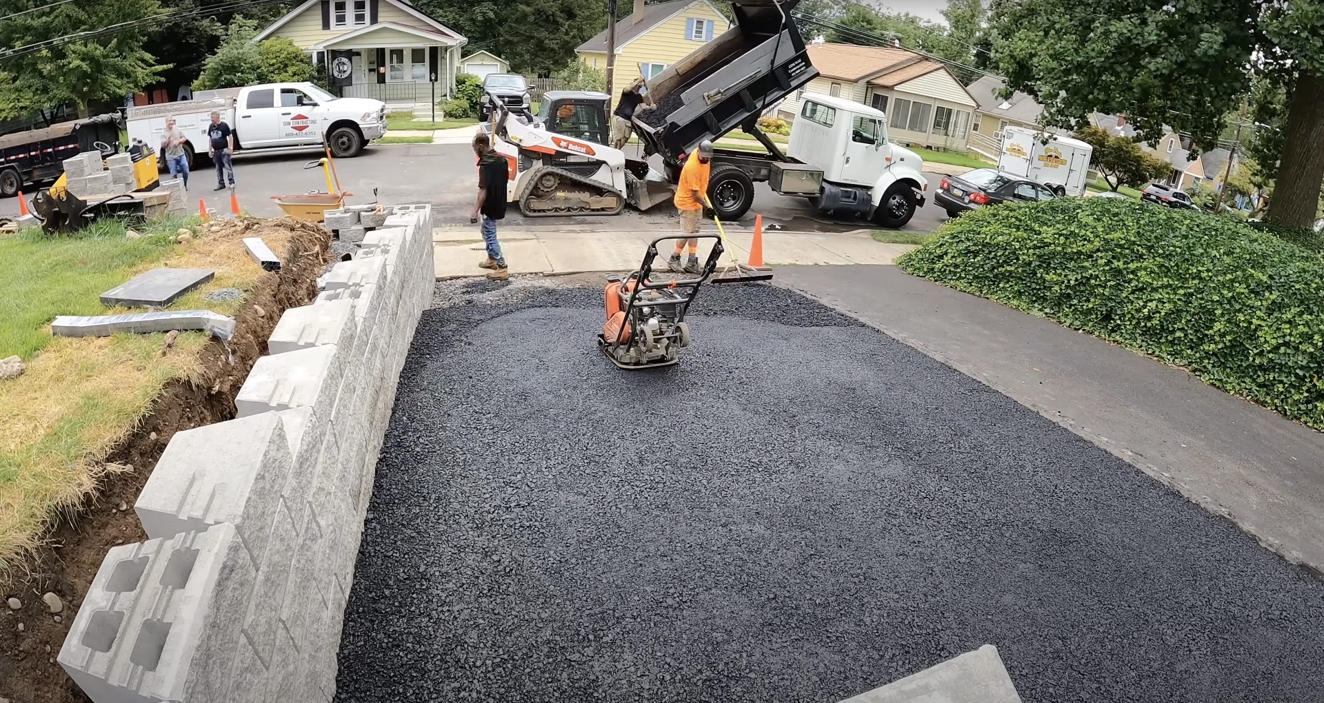 Experienced paving and concrete installation team at work Professional asphalt and concrete paving crew working on residential driveway in Waterbury CT